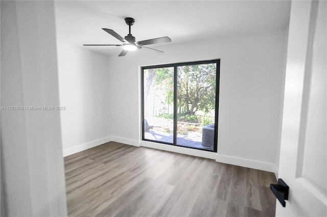 empty room with wood finished floors, baseboards, and ceiling fan