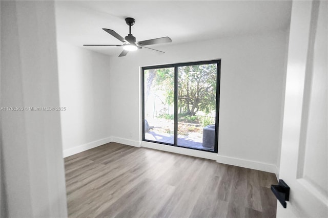 empty room featuring baseboards, a ceiling fan, and wood finished floors
