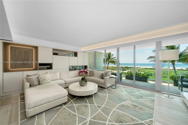 living area with a wall of windows and a water view