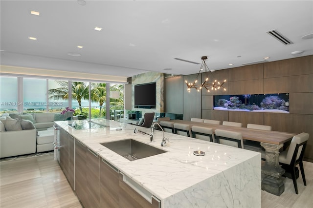 kitchen featuring a notable chandelier, modern cabinets, open floor plan, and a sink