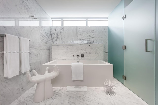 bathroom featuring a garden tub and a shower stall