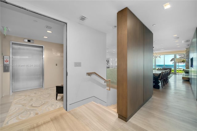 321 Ocean Dr Unit 200, Miami Beach, FL 33139 - corridor with visible vents, light wood finished floors, and an upstairs landing