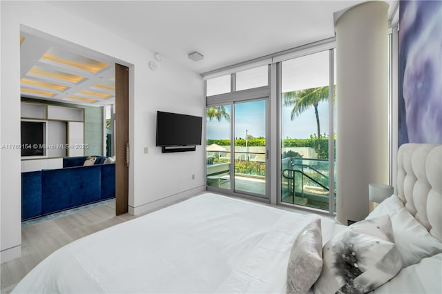 bedroom featuring wood finished floors, coffered ceiling, beam ceiling, access to exterior, and floor to ceiling windows