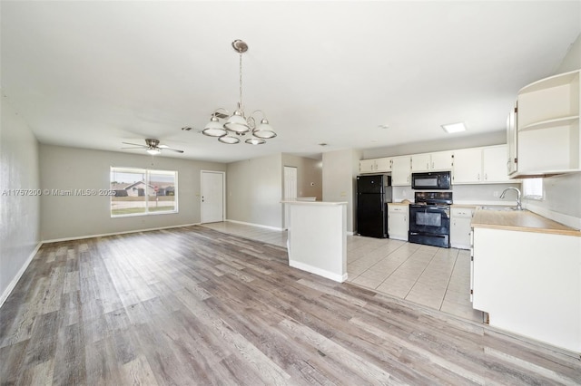 kitchen featuring black appliances, light wood-style flooring, a sink, white cabinets, and light countertops