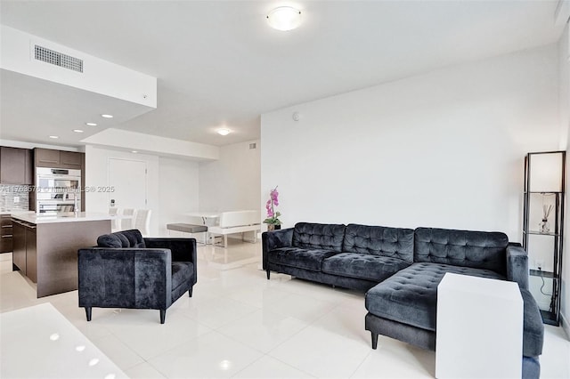 living area featuring light tile patterned floors, recessed lighting, and visible vents