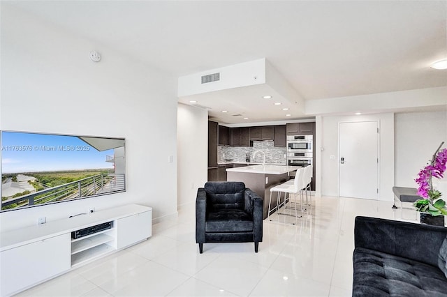 living room with light tile patterned floors, recessed lighting, visible vents, and baseboards