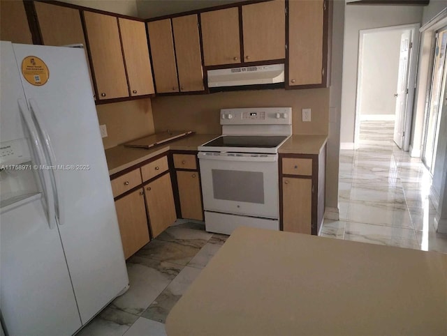 kitchen with under cabinet range hood, white appliances, and marble finish floor