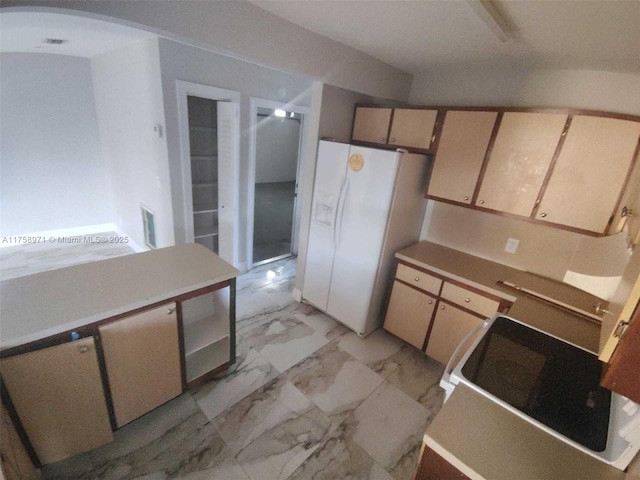 kitchen with arched walkways, white fridge with ice dispenser, marble finish floor, and light countertops