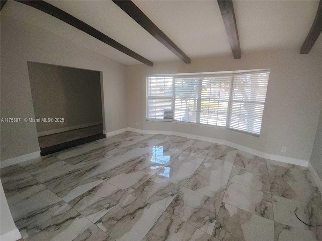 spare room with marble finish floor, lofted ceiling with beams, and baseboards