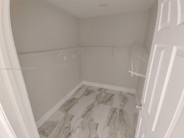 spacious closet with marble finish floor