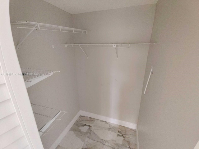 walk in closet with marble finish floor