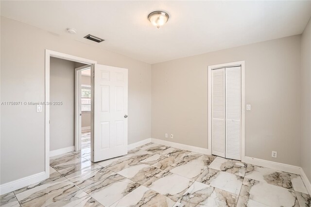 1281 Wyndcliff Dr, Wellington, FL 33414 - unfurnished bedroom featuring a closet, baseboards, and marble finish floor