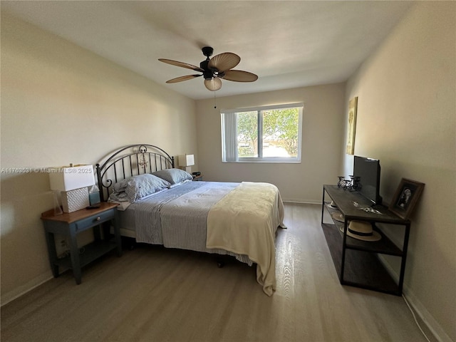 bedroom with light wood-style floors, baseboards, and ceiling fan