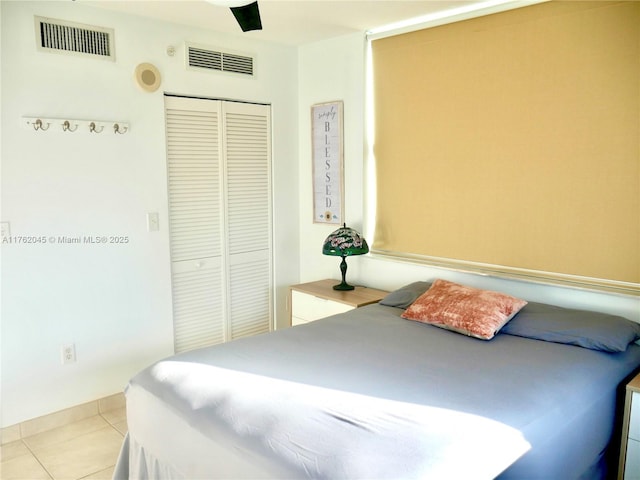 bedroom featuring visible vents, a closet, a ceiling fan, and tile patterned flooring