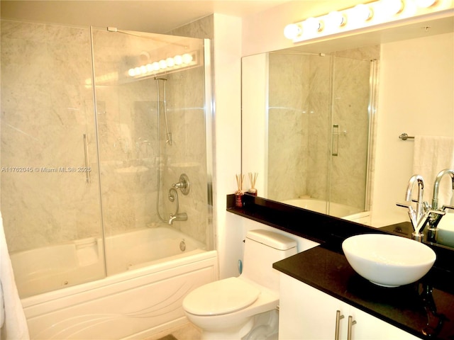 bathroom with combined bath / shower with glass door, toilet, and vanity