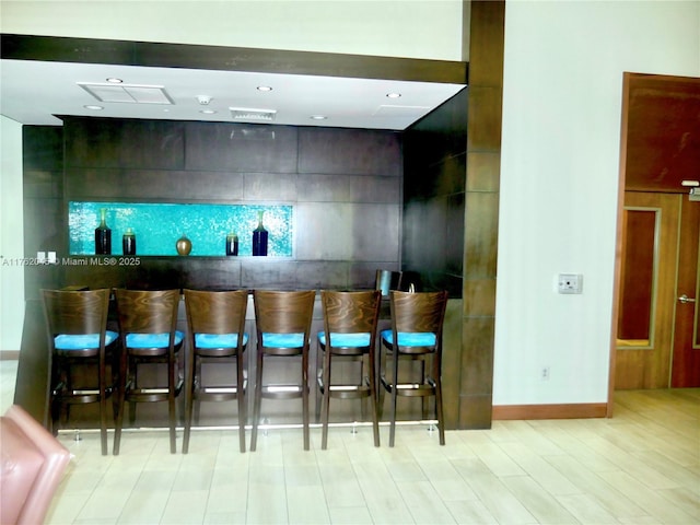 bar featuring a community bar and baseboards