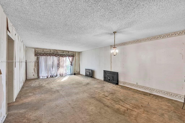 unfurnished living room featuring carpet flooring, a textured ceiling, and a wood stove