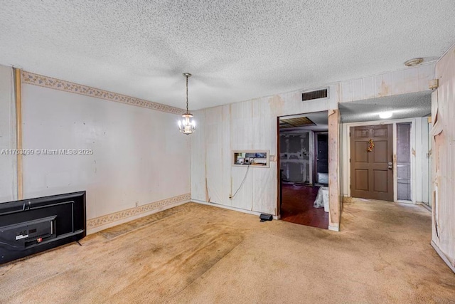 unfurnished dining area featuring visible vents, carpet flooring, and a textured ceiling