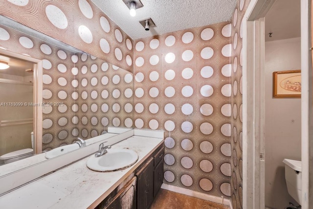 bathroom featuring a textured ceiling, toilet, vanity, and walk in shower