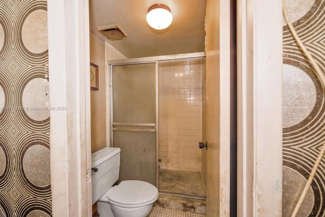 bathroom with visible vents, a shower stall, and toilet