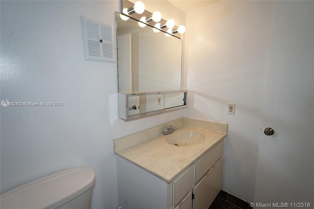 bathroom featuring visible vents, toilet, and vanity