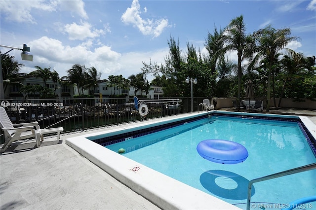 community pool featuring a patio area and fence