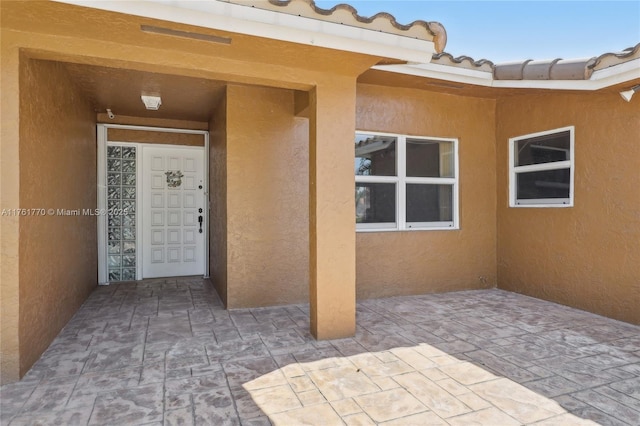 doorway to property with a patio and stucco siding