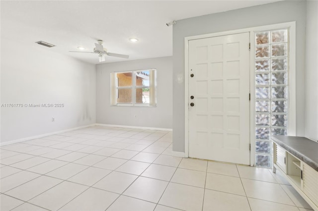 foyer entrance featuring light tile patterned floors, visible vents, baseboards, and a ceiling fan