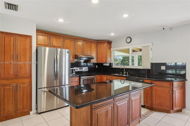 kitchen featuring visible vents, backsplash, under cabinet range hood, appliances with stainless steel finishes, and a sink