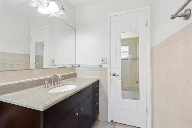 bathroom featuring tile patterned floors, tile walls, and vanity