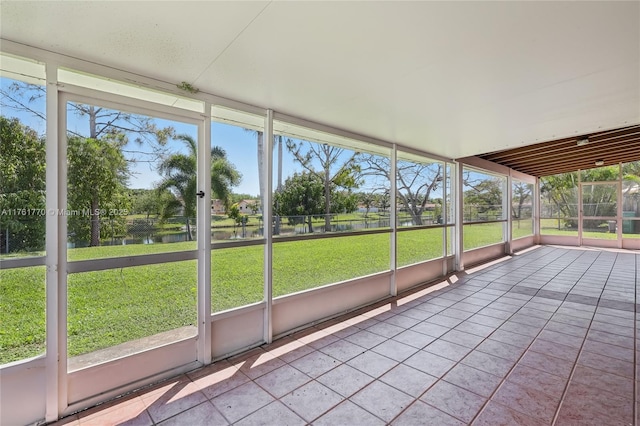 unfurnished sunroom with a water view