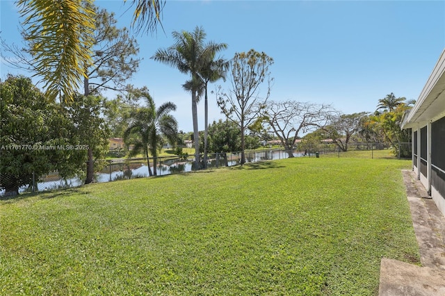 view of yard with a water view and fence