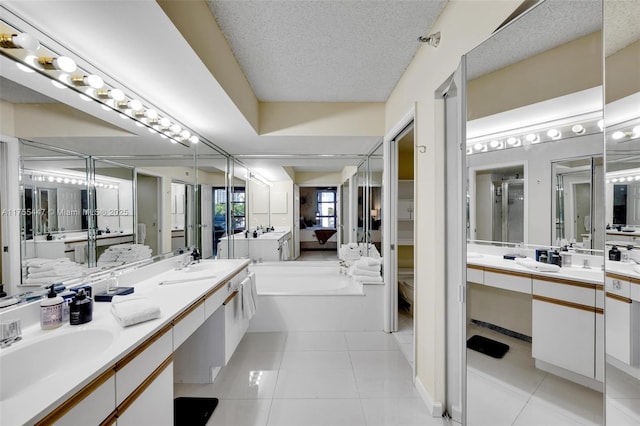 bathroom featuring vanity, a garden tub, a shower stall, a textured ceiling, and tile patterned floors