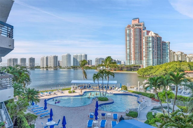 pool featuring a patio area, a view of city, and a water view