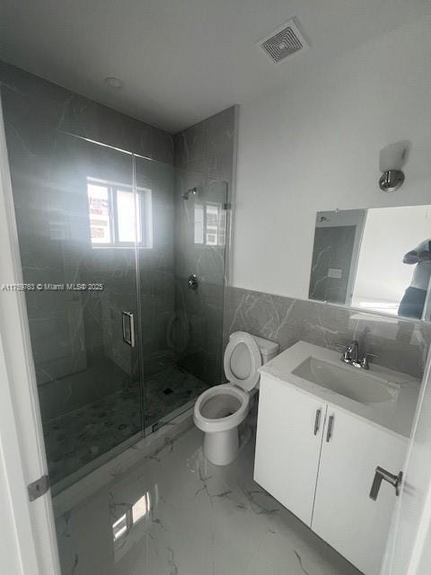 full bath with vanity, visible vents, a stall shower, toilet, and marble finish floor