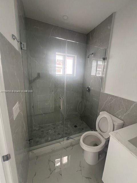 bathroom with vanity, a wainscoted wall, a marble finish shower, toilet, and marble finish floor