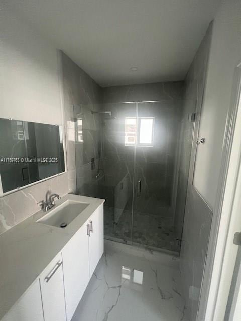 full bathroom with a marble finish shower, marble finish floor, and vanity