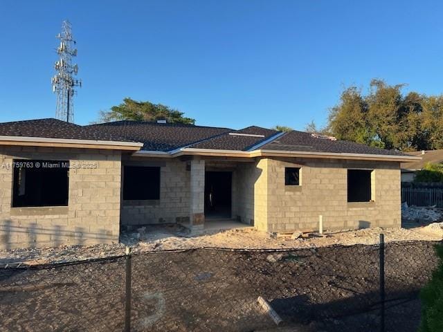 view of front of home with roof with shingles and fence