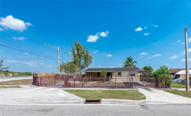 single story home featuring driveway and a fenced front yard