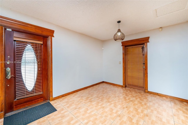 interior space with a textured ceiling and baseboards