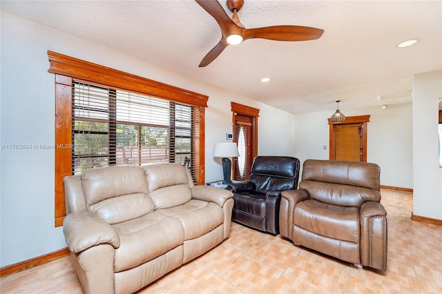 living area featuring recessed lighting, baseboards, a textured ceiling, and ceiling fan