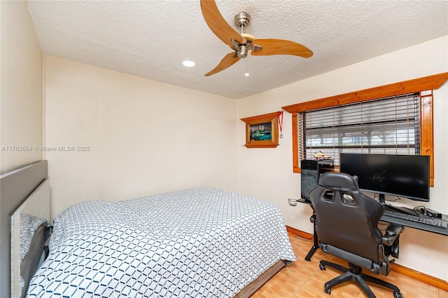 bedroom featuring baseboards, a textured ceiling, and ceiling fan