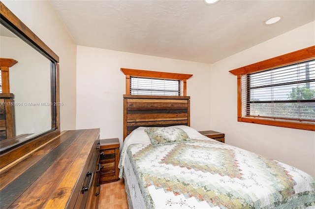 bedroom with light wood finished floors and recessed lighting