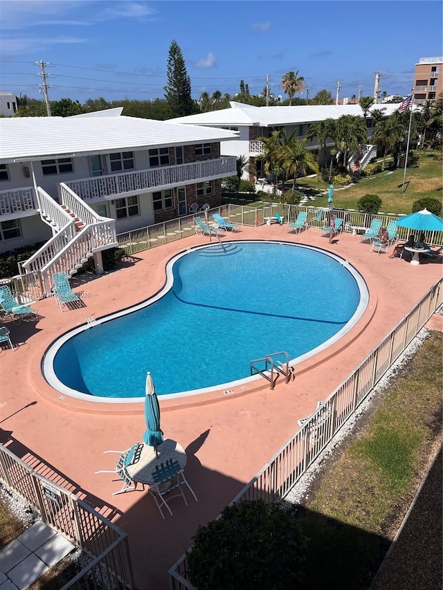 community pool featuring a patio area and fence