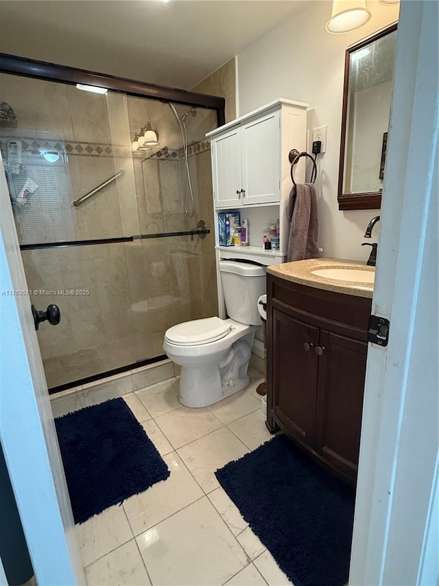 bathroom with tile patterned floors, toilet, a stall shower, and vanity