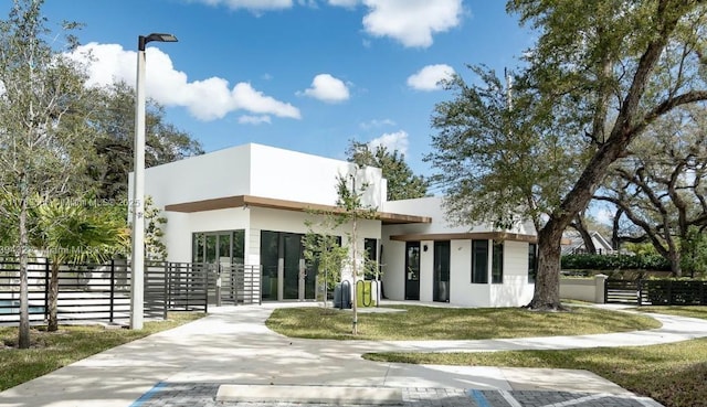 rear view of property featuring stucco siding and fence