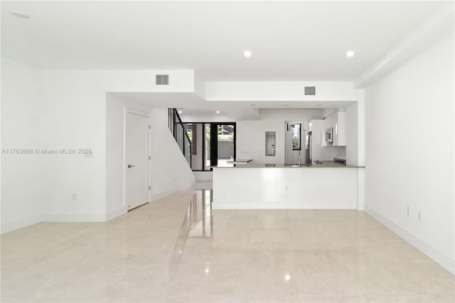 interior space featuring stairway, baseboards, and visible vents