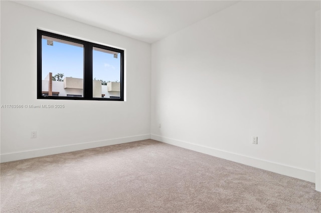 carpeted spare room with baseboards