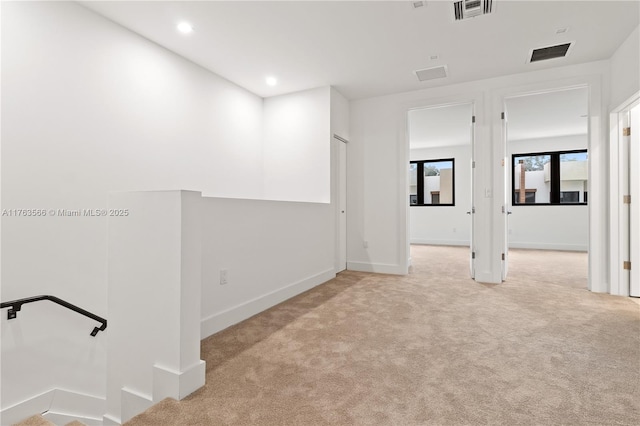 carpeted empty room featuring recessed lighting, visible vents, and baseboards