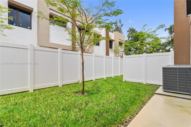 view of yard with central AC unit and fence